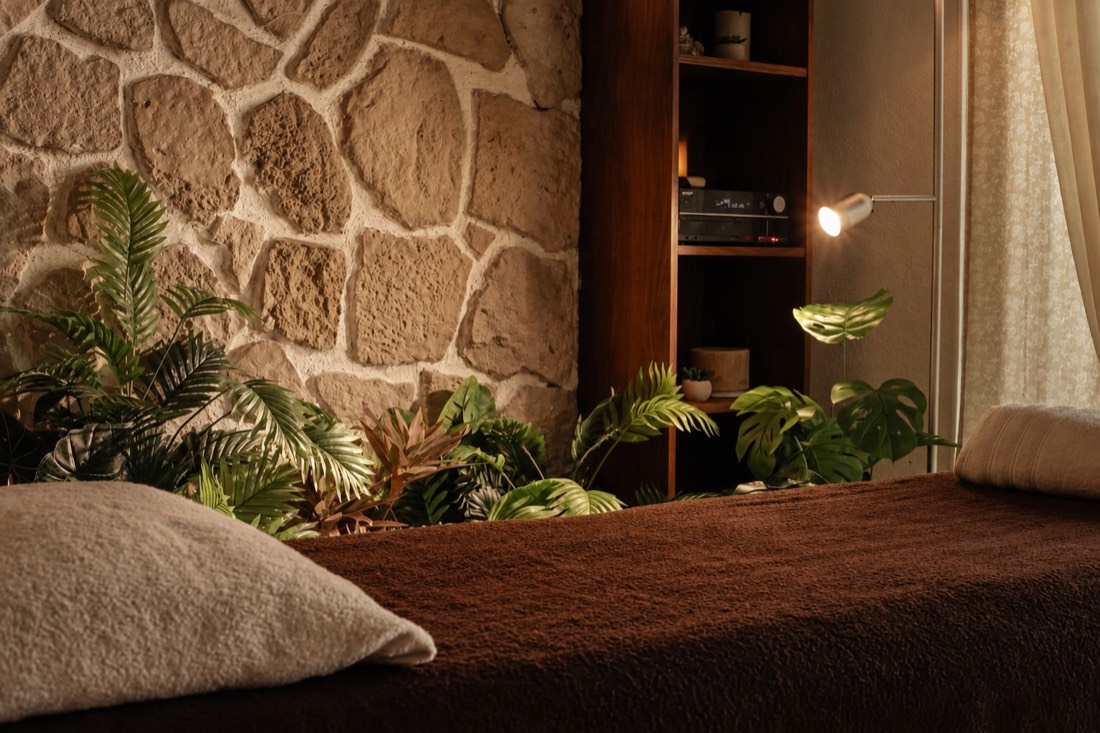 Table de massage, pierre naturelle et plantes dans la cabine